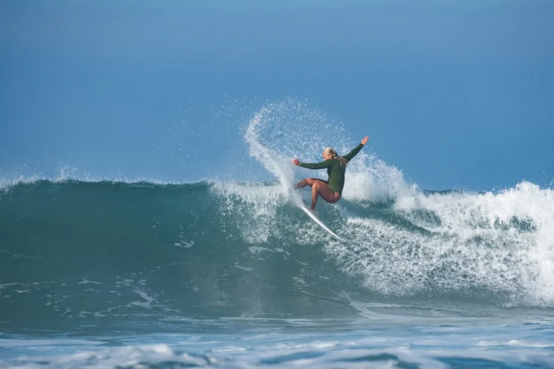 A surfer carving a turn on a blue wave in Southern California
